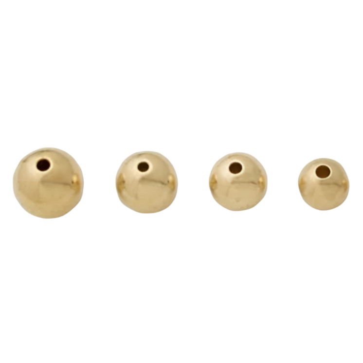 Four gold-colored hollow metal beads on a white background